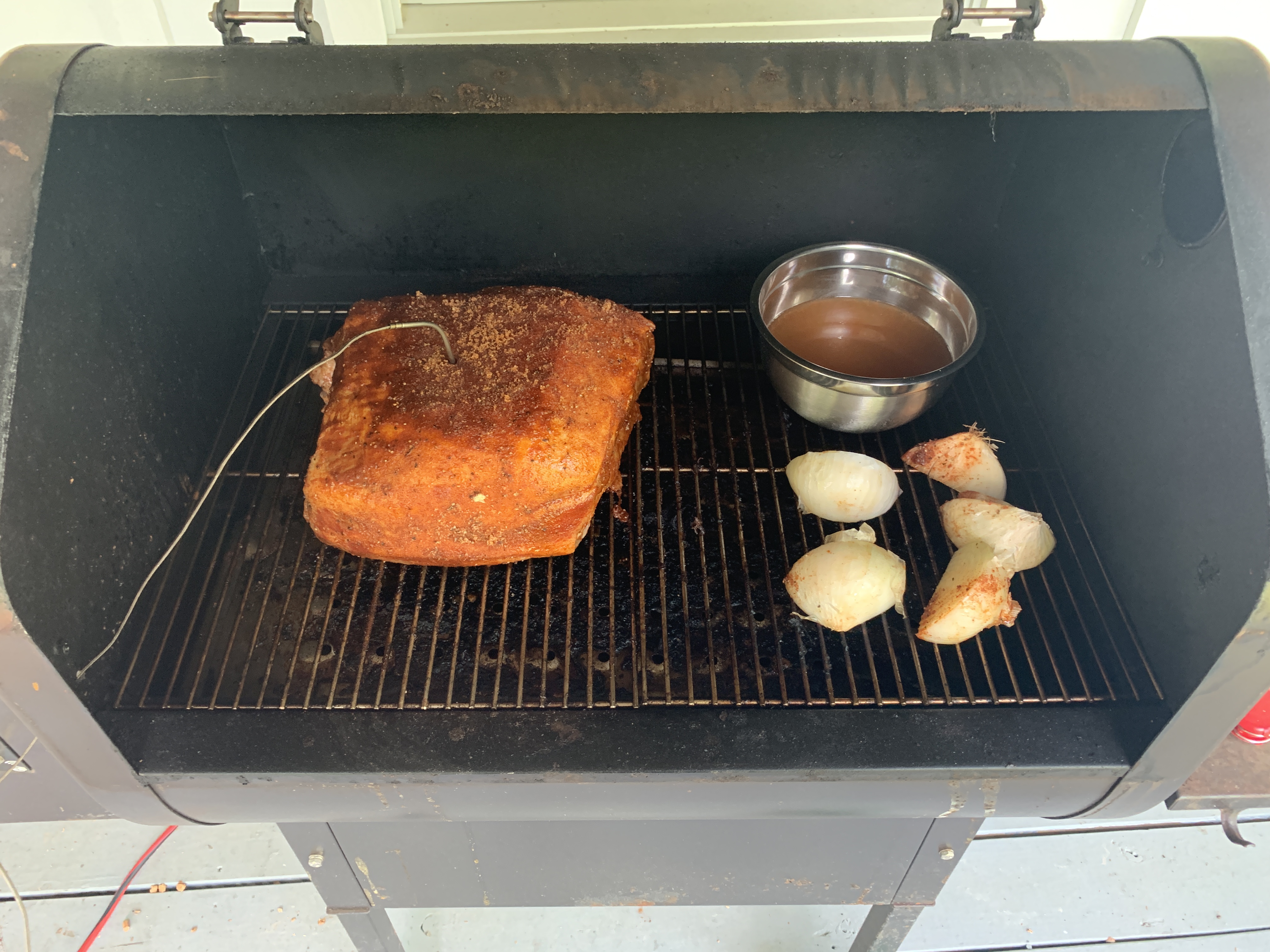 Prepared pork shoulder placed into smoker.